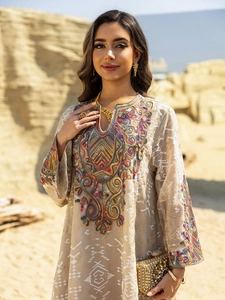 Detailed view of intricate ethnic embroidery on a khaki maxi dress with golden thread