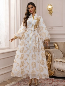 Close-up of white Jalabiya dress featuring gold leaf embroidery and lantern sleeves