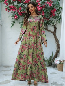 Detail of green floral kaftan dress with long sleeves and delicate neckline piping