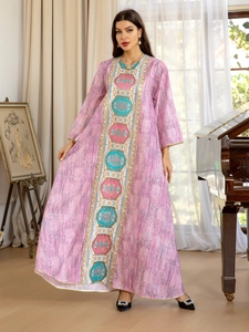 Détail de la robe caftan violet-rose avec motifs ethniques géométriques et bordure dorée