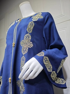 Détail de la broderie dorée et des boutons boules sur cette robe maxi ethnique bleu marine
