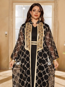 Details des eleganten schwarzen langen Kleides mit Goldstickerei und durchsichtigem Cardigan