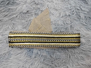 Detailed close-up of embroidered Tanjak headwear with golden threads on a textured surface