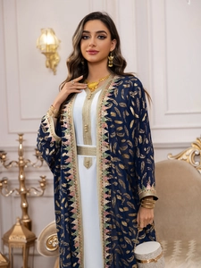 Détail de la robe en mousseline marine avec motifs dorés et garnitures métalliques d'ornement