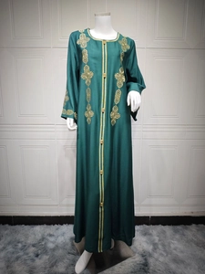 Broderies dorées détaillées sur abaya vert foncé avec texture traditionnelle