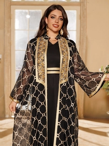 Detail einer eleganten schwarzen Abaya mit goldener geometrischer Stickerei und Blumenhals