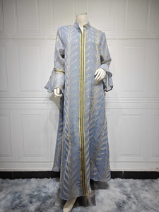 Detail of light blue embroidered abaya with golden leaf patterns and flared sleeves