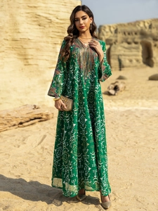 Détail de la broderie ethnique et des glands sur une robe caftan vert foncé