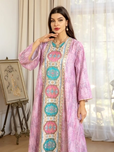 Détail de la broderie géométrique colorée et du perlage sur la robe caftan rose chic