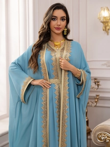 Detail of light blue chiffon kaftan with intricate gold embroidery and lace trim