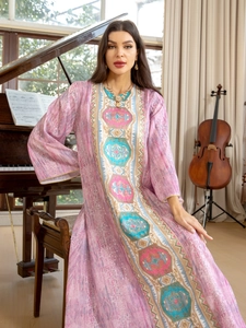 Gros plan d'une robe bohème rose avec broderie ethnique complexe et tissu scintillant