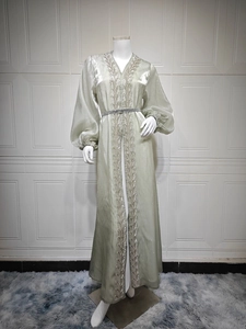 Detail of elegant puff sleeves and intricate lace embroidery on green gown