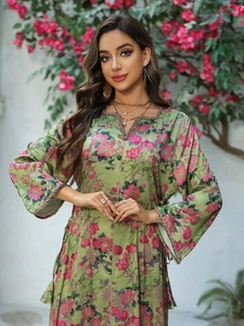 Detail of floral printed green maxi dress featuring sequin neckline and metallic tassels