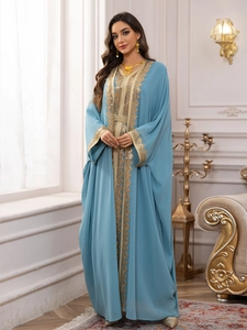 Detail of light blue chiffon kaftan with intricate gold sequin embroidery and woven belt