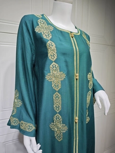 Broderies dorées détaillées sur robe caftan en satin vert foncé à manches longues