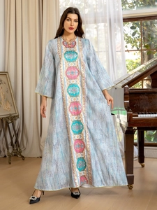Détails de broderie géométrique colorée sur robe longue bleu clair scintillante