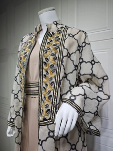 Detail eines beige gestickten Cardigans und khakifarbenen Maxikleids auf einer Schaufensterpuppe