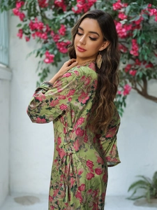 Detailed close-up of side drawstring and floral satin fabric on this green long dress