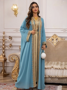 Detail of light blue chiffon kaftan dress with intricate gold lace embroidery and sequins