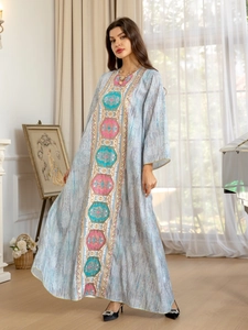 Détail de robe caftan bleue avec broderie géométrique et silhouette longue jusqu'au sol