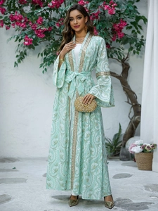 Dettaglio del ricamo di paillettes dorate sull'abaya verde menta con maniche a campana