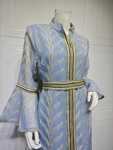Detail of light blue embroidered kaftan dress with trumpet sleeves and ethnic trim