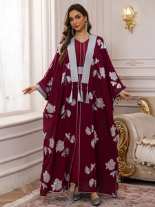 Détail du caftan bordeaux avec broderie florale argentée et glands à franges