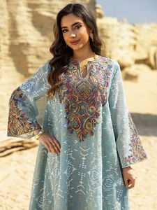 Detailed close-up of colorful embroidery and sequins on light blue mesh maxi dress