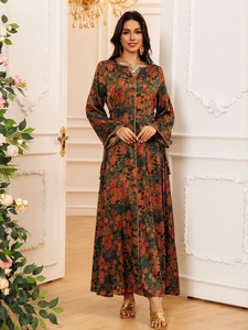 Detail of floral print maxi dress featuring elegant gold trim on cuffs and neckline