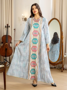 Détail de la robe bleu clair avec broderie géométrique colorée et coutures dorées