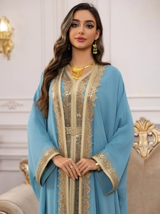 Detail of light blue chiffon Abaya with intricate gold embroidery and a woven belt