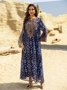 Detail of intricate colorful embroidery and beadwork on a navy mesh maxi dress