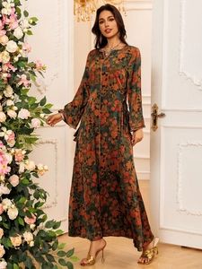 Detailed view of floral printed maxi dress with luxurious gold jewelry and accessories