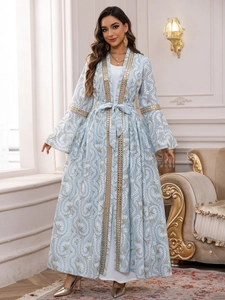 Dettaglio dell'abaya celeste ricamata con finiture di paillettes dorate e fiori