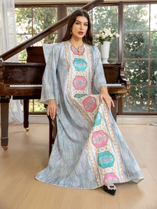 Détails de broderie ethnique et liseré doré sur une robe caftan de couleur bleu clair
