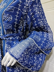 Détail de la robe en tulle bleu roi avec broderie géométrique blanche et perles décoratives