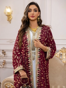 Détail du tissu bordeaux avec broderie de plumes dorées et bordures ethniques