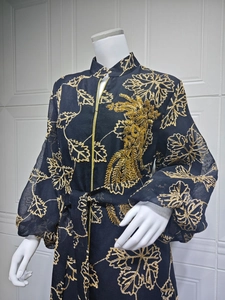 Close-up of golden leaf embroidery and intricate sequin feather details on black Jalabiya