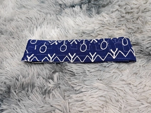 Gros plan de la broderie blanche sur robe en tulle bleu marine avec motifs géométriques