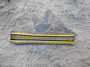 Detailed embroidery on blue denim fabric with intricate gold patterns on ethnic headwear