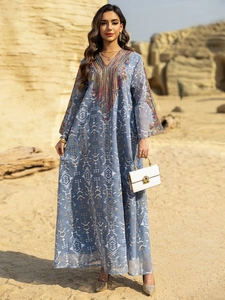 Robe longue caftan bleue avec broderie ethnique et imprimé géométrique dans le désert