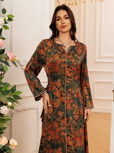 Detail of bohemian floral maxi dress featuring gold braided trim and jewel pendant neckline