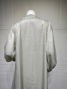 Detail of light green satin robe with glittering rhinestones and elegant puff sleeves