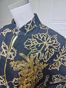 Detail of heavy gold embroidery and beaded floral patterns on black Jalabiya dress