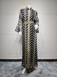 Detail of elegant black kaftan with golden leaf embroidery and flared bell sleeves