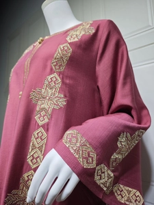 Détail de la broderie géométrique dorée et des perles sur la manche du caftan rose foncé