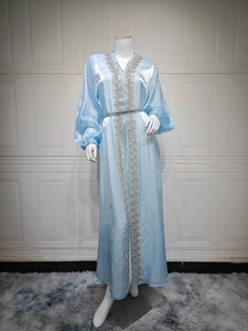 Close-up of light blue satin kaftan dress with silver embroidery and lantern sleeves
