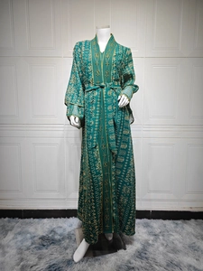 Détail de la robe élégante en maille verte avec broderie dorée et ceinture assortie