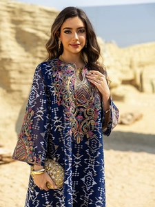 Detailed close-up of intricate colorful embroidery and sequins on navy blue kaftan dress