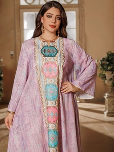 Gros plan détaillé sur les broderies ethniques et paillettes de cette robe caftan